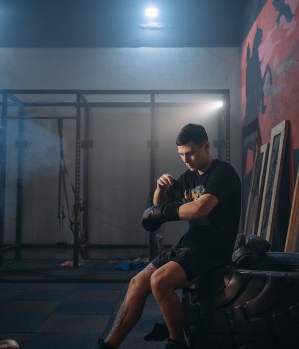Man performing a controlled strength exercise in a dark gym with lime green light.